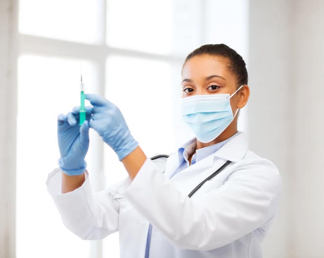 African American doctor holding needle syringe