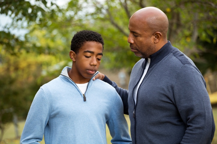 father talking to sad son
