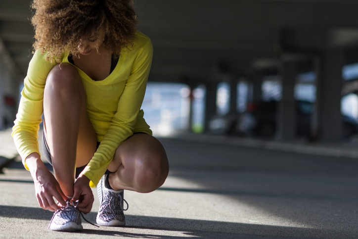 African American womanwoman tying shoe before workout