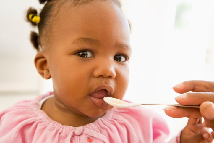 African American baby girl eating food