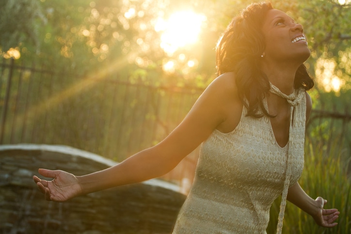 African American woman open arms thankful