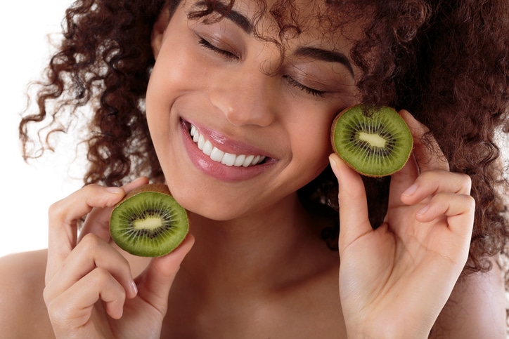 African American woman holding kiwi