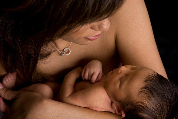 African American mother holding baby kangaroo care
