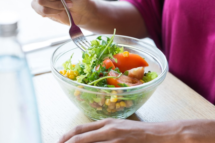 African American woman eating salad