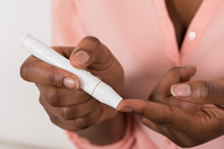 African American woman checking blood sugar