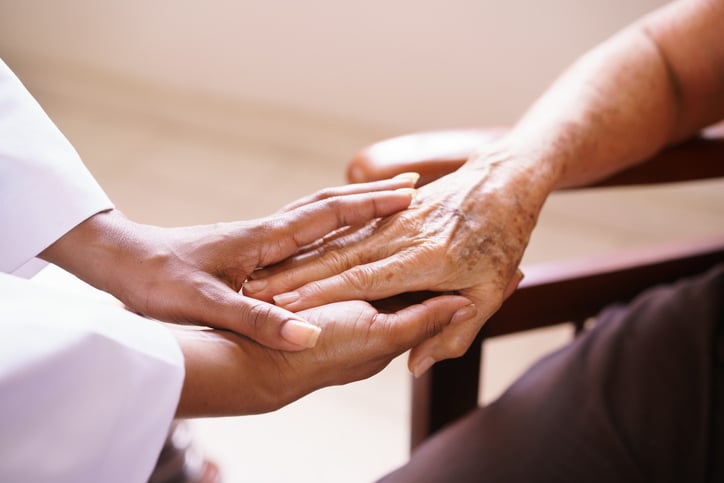 African American doctor holding female patient hand