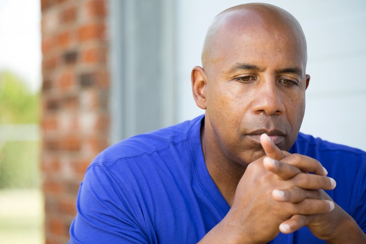 Older African American man looking thoughtful sad