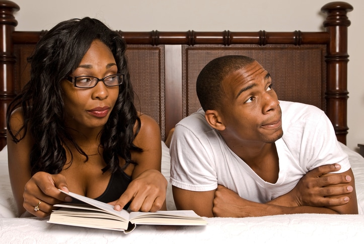 African American couple in bed reading
