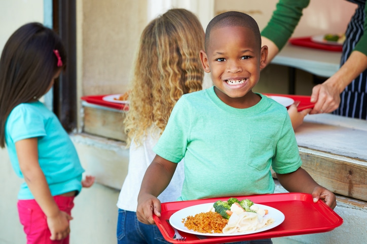 African American boy eating school lunch