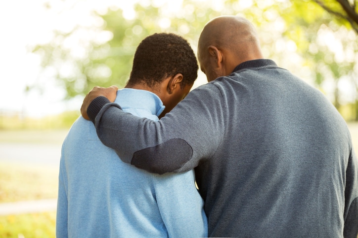 African American father and son hugging