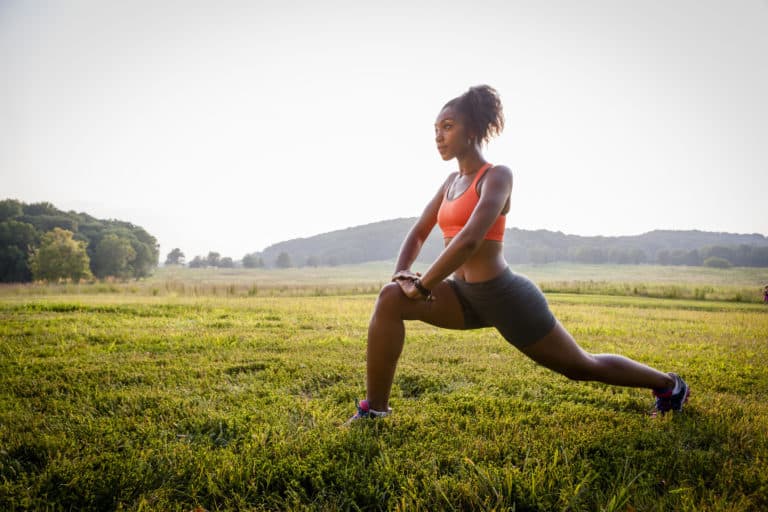 Young female runner stretching