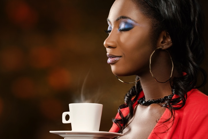 African American woman smelling coffee