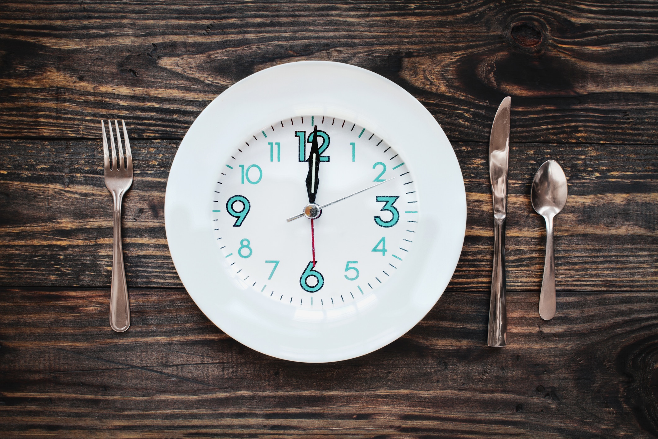 Twelve hour intermittent fasting time concept with clock on plate.