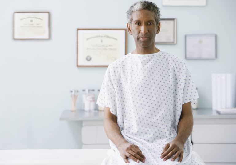 African man wearing hospital gown