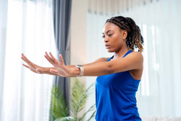 a woman in a blue shirt stretching her arms